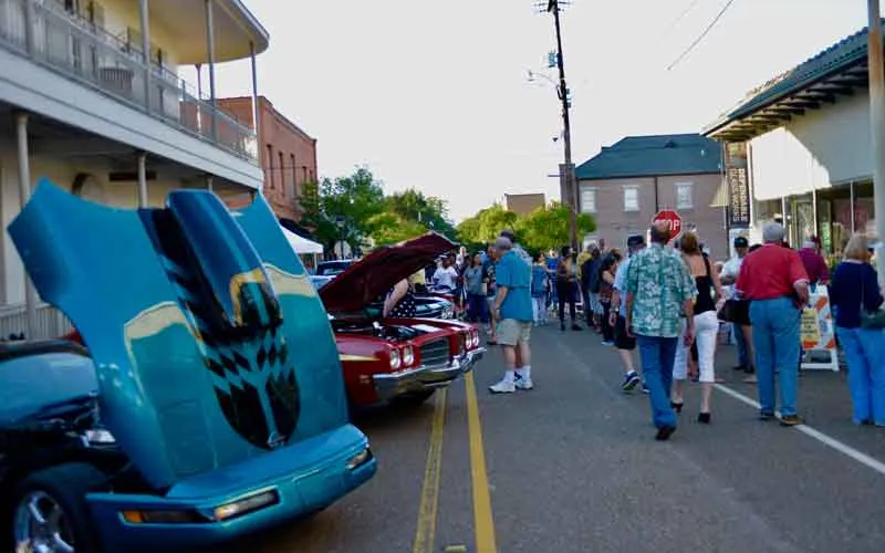 Classic cars and visitors along a downtown Covington street